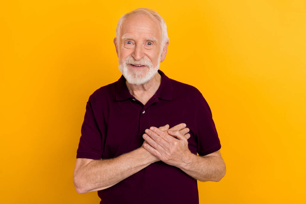 Φωτογραφία από αστείο ηλικιωμένος άνδρας κατέχουν παλάμες φορούν βατόμουρο t-shirt που απομονώνονται σε κίτρινο χρώμα φόντο - Φωτογραφία, εικόνα