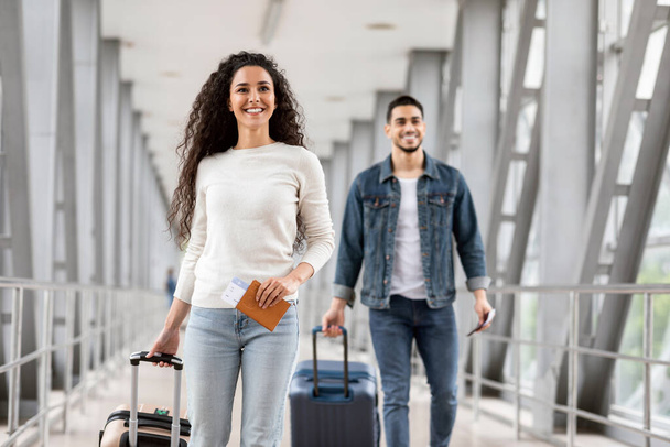 Koncepcja podróży lotniczych. Szczęśliwy mężczyzna i kobieta spacerujący z walizkami na lotnisku - Zdjęcie, obraz