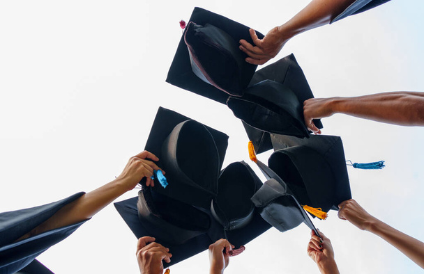 Graduation Caps ρίχνονται στους αποφοίτους επιτυχία αέρα του πανεπιστημίου, Concept εκπαίδευση συγχαρητήρια αποφοίτους στο Πανεπιστήμιο. - Φωτογραφία, εικόνα