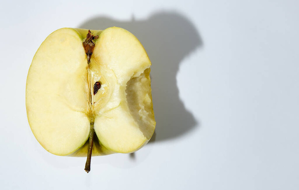 Bitten apple on white background. Raw half an apple. Fresh green apple with a shadow.  - Фото, изображение