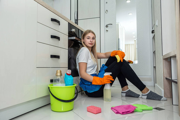 limpieza, limpieza de criada bastante joven con aerosol y esponja en ktchen, trabajo en casa - Foto, Imagen