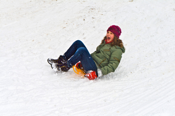 Chica trineo abajo de la colina en la nieve
 - Foto, Imagen