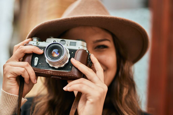 Fiatal spanyol turista nő mosolyog boldog segítségével vintage kamera a városban. - Fotó, kép