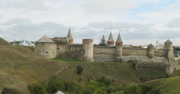 Panoraamanäkymät muinainen linnoitus Kamenetz Podolsky Ukraina. Pilvistä, vihreää ruohoa ja rotkoa linnan edessä. Laaja laukaus torneissa - Materiaali, video