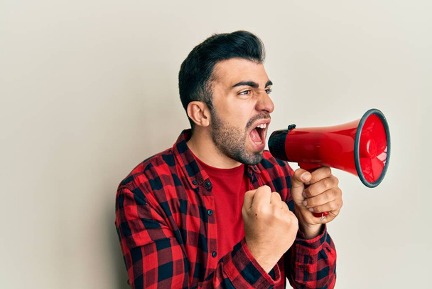 Ισπανόφωνος άντρας με γενειάδα ουρλιάζοντας με μεγάφωνο - Φωτογραφία, εικόνα