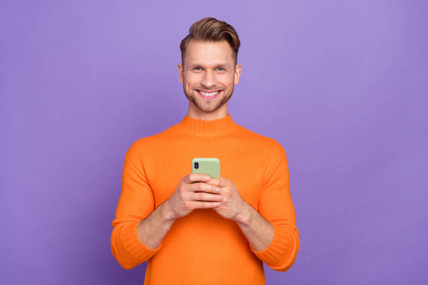 Photo of good mood positive man chatting with girlfriend in cellphone gadget isolated on purple color background - Φωτογραφία, εικόνα
