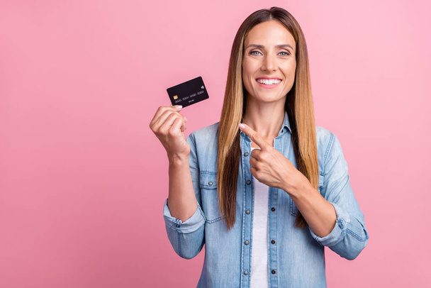 Photo of young cheerful woman indicate finger credit card benefit promo select isolated over pink color background - Zdjęcie, obraz
