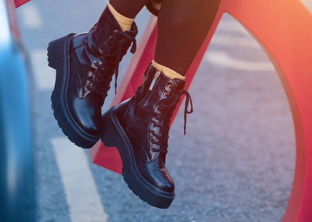 πόδια μιας γυναίκας με μαύρα παπούτσια στο δρόμο της πόλης την κρύα μέρα - Φωτογραφία, εικόνα