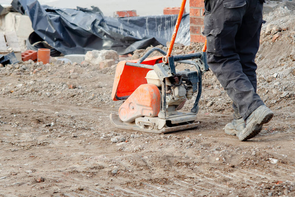 Light ground compactor used by groundworker on construction site - 写真・画像
