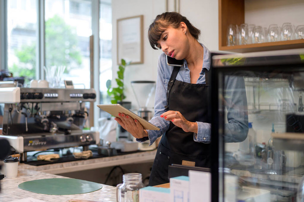 Young service minded barista woman working in coffee shop - Фото, зображення