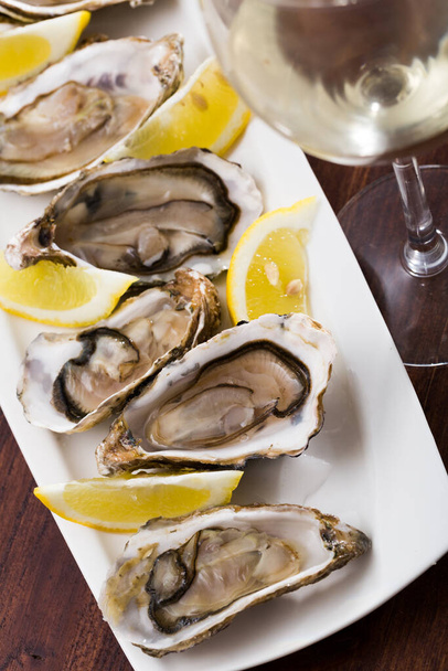 Opened raw oysters with lemon - Fotoğraf, Görsel