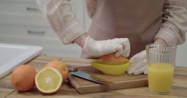 Nő csinál friss narancslé a konyhában, közelkép - Felvétel, videó