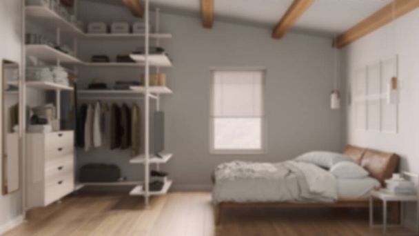 Blur background, modern minimalist bedroom with walk-in closet, parquet floor, wooden beams ceiling, bed with duvet and pillows. Window with blinds. Contemporary interior design - 写真・画像