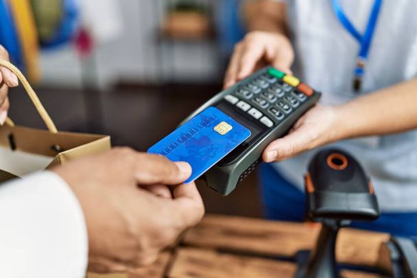 Homem e mulher de meia idade usando cartão de crédito e telefone de dados pagando na loja de roupas - Foto, Imagem