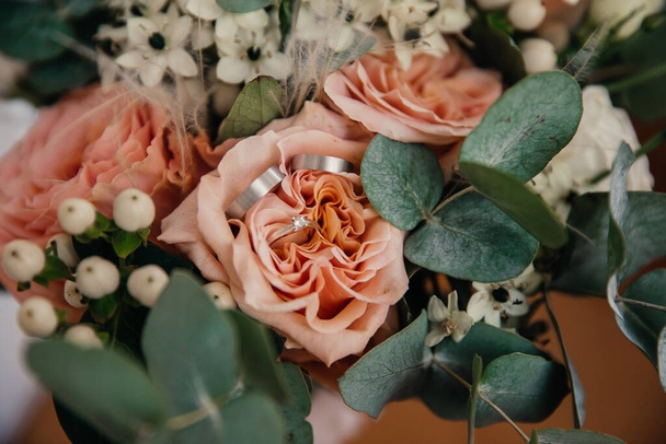 anillos de boda en un capullo de flores en un ramo de bodas - Foto, Imagen