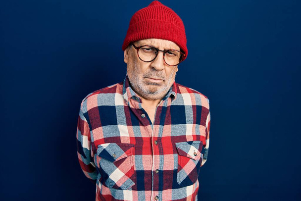 Handsome mature man wearing hipster look with wool cap skeptic and nervous, frowning upset because of problem. negative person.  - Фото, изображение