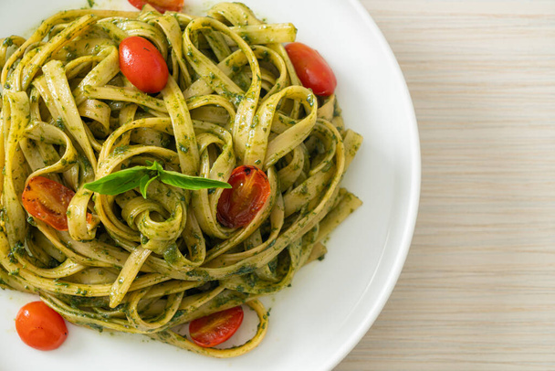 fettuccine spaghetti pasta with pesto sauce and tomatoes - vegan and vegetarian food style - Fotó, kép