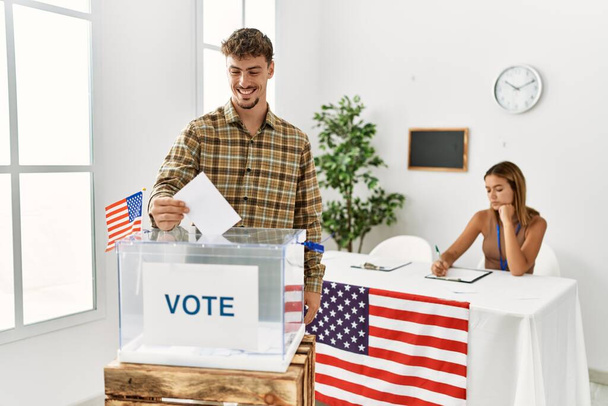Młody amerykański wyborca oddający głos w urnie wyborczej w kolegium wyborczym. - Zdjęcie, obraz