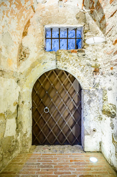 Vista sobre uma antiga porta de ferro do Castelo de Liubliana dentro das masmorras - Foto, Imagem