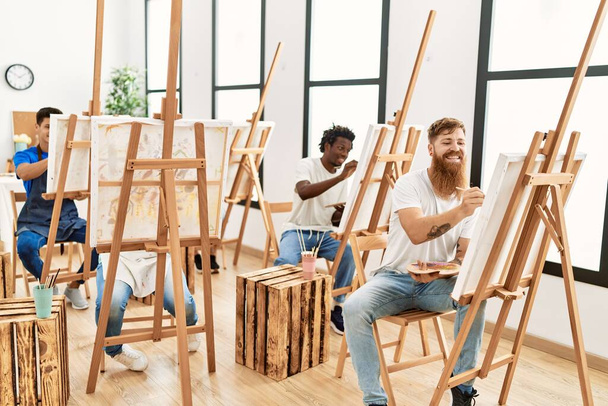 Группа людей, улыбающихся счастливому рисунку в художественной студии. - Фото, изображение