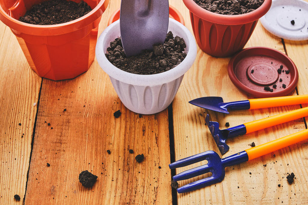 Flower pots and set decorative gardening tools shovel, rake and pitchfork on a wooden background - Foto, Imagem