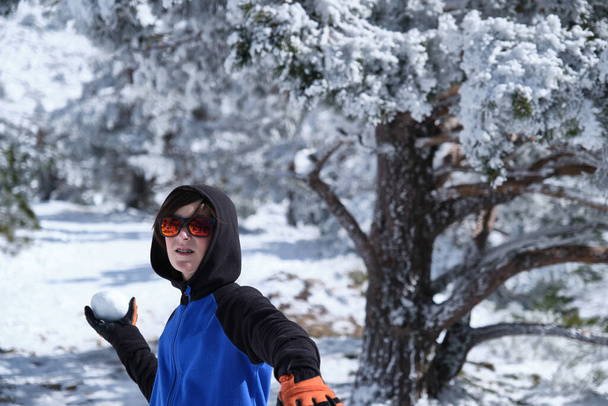 Rapaz jogando bola de neve na floresta - Foto, Imagem