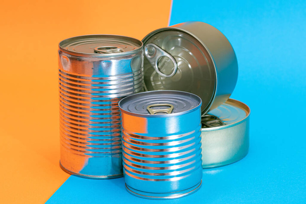 A Group of Stacked Tin Cans with Blank Edges on Split Blue and Orange Background - Фото, зображення