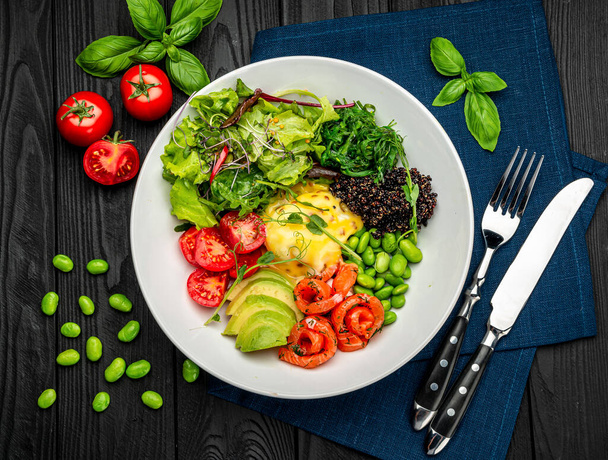 Healthy light breakfast with poached egg, salmon, avocado, tomato, lettuce and chia seeds, business lunch. Serving food in a restaurant. Healthy food concept. Photo for the menu - Photo, Image