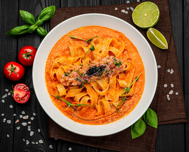 サーモンタルタルとトマトソースのパスタ,イタリア料理.レストランで食事を提供しています。健康食品の概念。メニューの写真 - 写真・画像