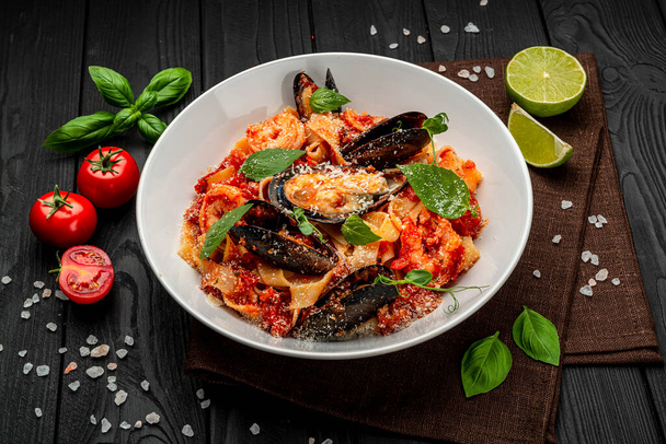 Italian seafood spaghetti pasta pescatore with mussels clams shrimp. Serving food in a restaurant. Healthy food concept. Photo for the menu - 写真・画像