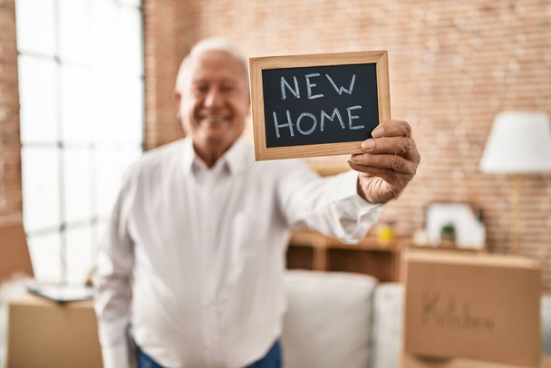 Idősebb férfi mosolyog magabiztos tartja táblán az új otthon - Fotó, kép