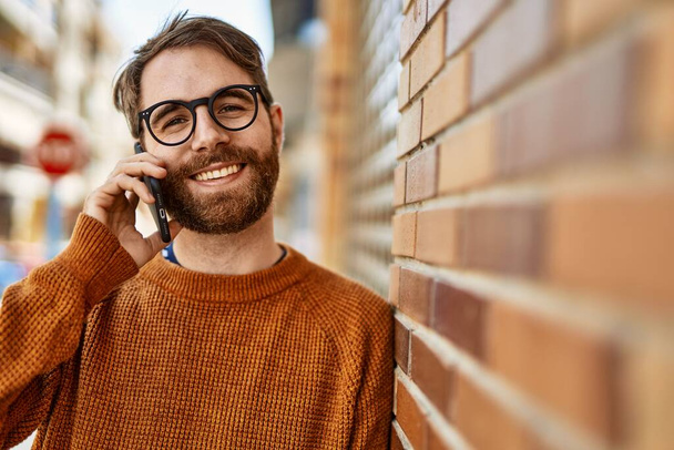 Beyaz sakallı bir adam güneşli bir günde telefonda konuşuyor. - Fotoğraf, Görsel