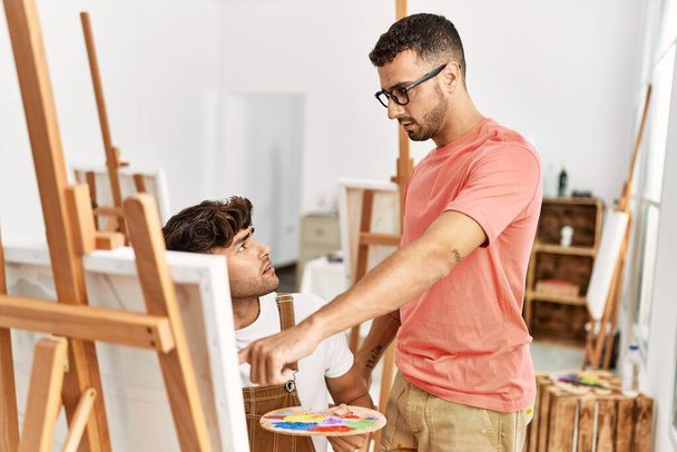 Dos maestros y estudiantes hispanos dibujando en un estudio de arte - Foto, Imagen