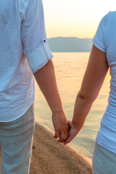 пара тримає руки на березі
 - Фото, зображення