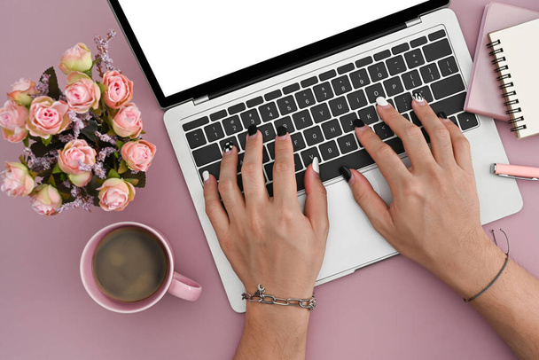 Mujer joven usando ordenador portátil sobre fondo rosa
. - Foto, imagen