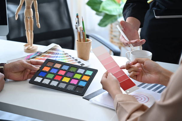 Des gens créatifs utilisant des échantillons de couleur et travaillant ensemble dans un studio de design. - Photo, image
