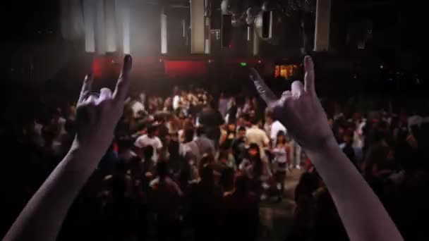 Vrouwelijke Hand toont Rock n Roll Sign op een Disco met een wazig publiek op de achtergrond.    - Video