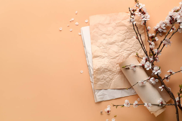 Beautiful blooming spring branches and vintage paper on beige background, top view - Photo, Image