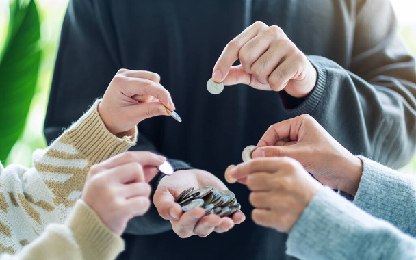Closeup image of people putting coins into another people's hands - Photo, Image