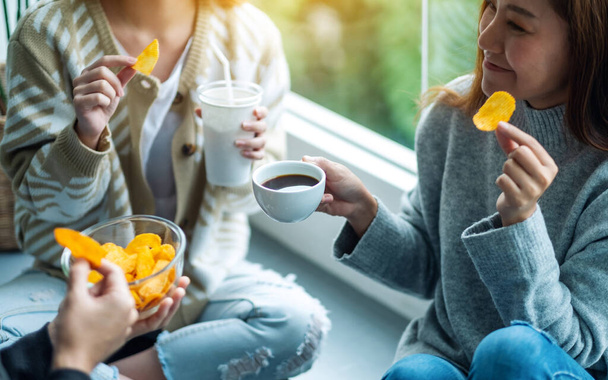 Closeup image of friends drinking and eating potato chips together - Foto, Imagem