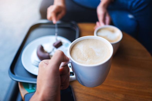 Крупним планом зображення двох людей смердить білі чашки кави в кафе
 - Фото, зображення