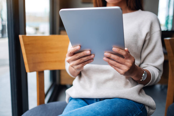 Nahaufnahme einer Frau, die ein digitales Tablet hält und benutzt  - Foto, Bild