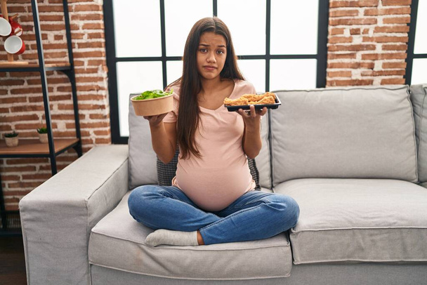 Молода вагітна жінка прагне їжі вдома скептично і нервово, розчаровуючись через проблеми. негативна людина
.  - Фото, зображення