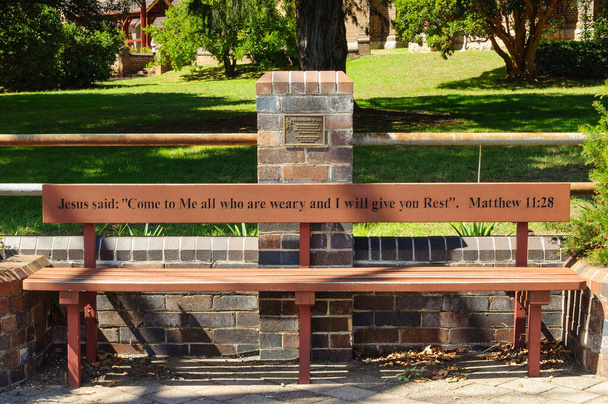 Die Einladung (Matthäus 11,28) auf einer Bank der anglikanischen Kathedrale St. Peter an der Ecke Dangar und Rusden Street - Armidale, NSW, Australien - Foto, Bild