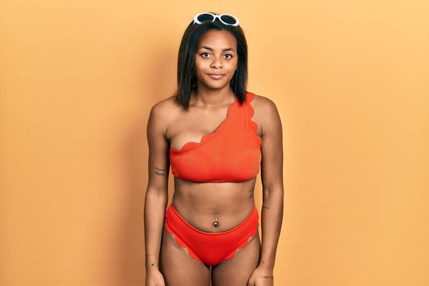 Junge afrikanisch-amerikanische Mädchen im Bikini entspannt mit ernstem Gesichtsausdruck. einfacher und natürlicher Blick auf die Kamera.  - Foto, Bild