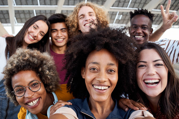 Junge Afroamerikanerin macht ein Handy-Foto mit ihrer multirassischen Gruppe von Freunden. Konzept der Freundschaft, Spaß haben. - Foto, Bild