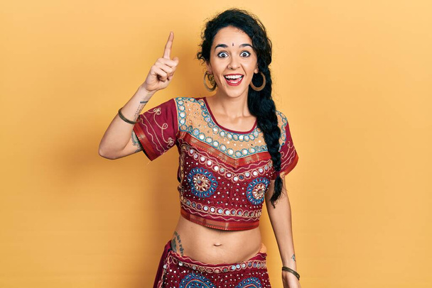 Młoda kobieta w bindi i bollywoodzkiej odzieży wskazującej palcem na udany pomysł. Wyszedł i był szczęśliwy. numer jeden.  - Zdjęcie, obraz