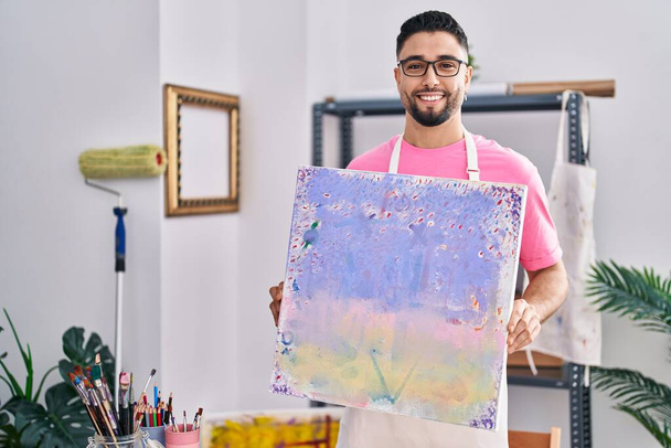 Nuori arabi mies taiteilija hymyilee luottavainen tilalla piirtää art studio - Valokuva, kuva