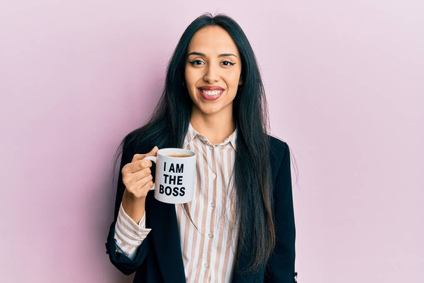私から飲む若いヒスパニック系の女の子私は上司のコーヒーカップ見て正と幸せな立ちと笑顔で自信を持って笑顔歯を示す  - 写真・画像