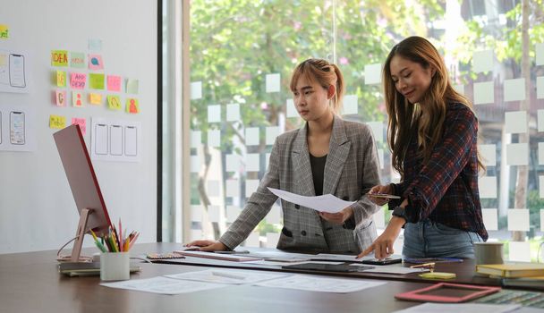 Two young women creative designers working, planning application template layout framework for mobile application. - 写真・画像